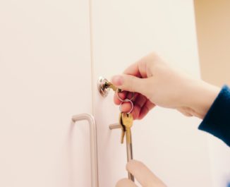 A female locking a cabinet showing us how to childproof your house.