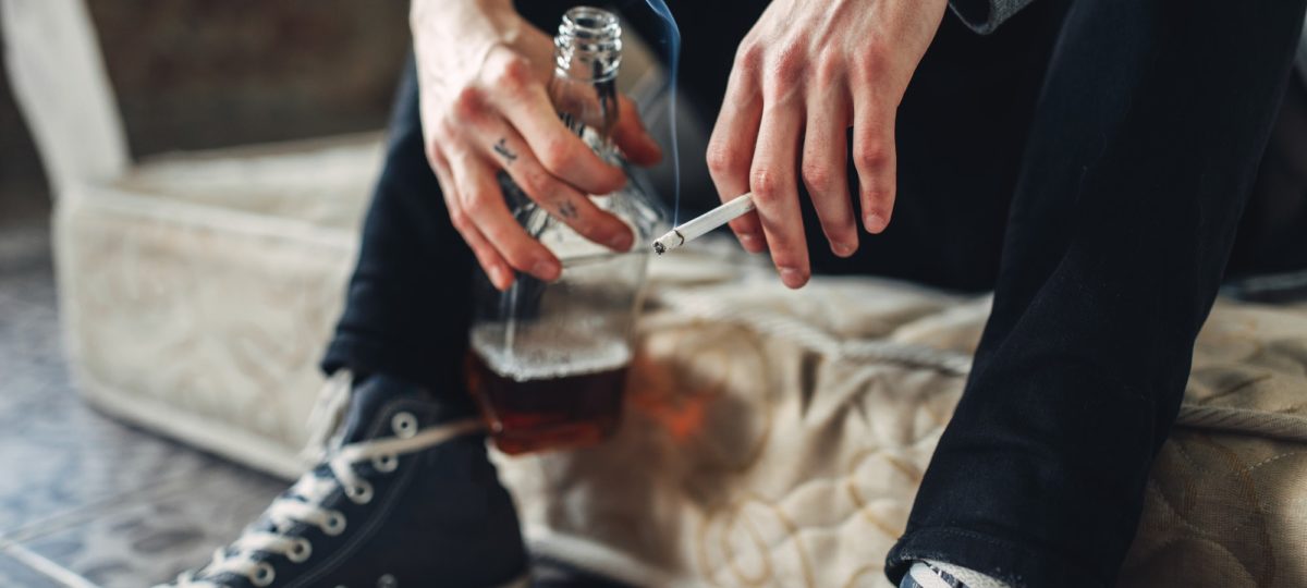 Addicted male person with cigarette and alcohol