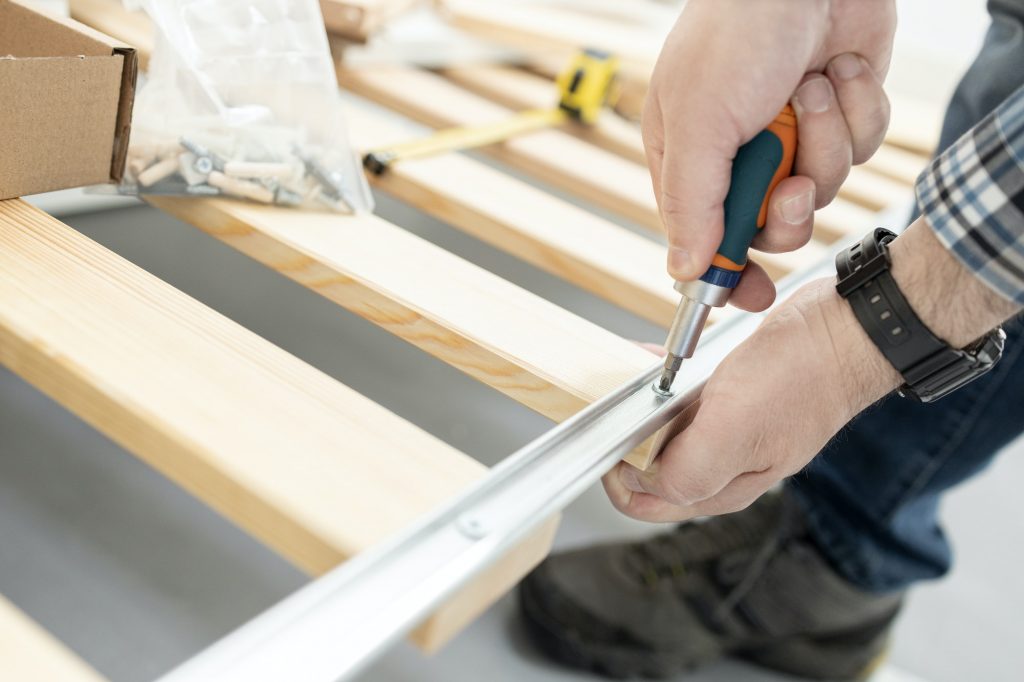 Close up of hands Assembling a bed frame using a screwdriver. Frames or boxsprings?