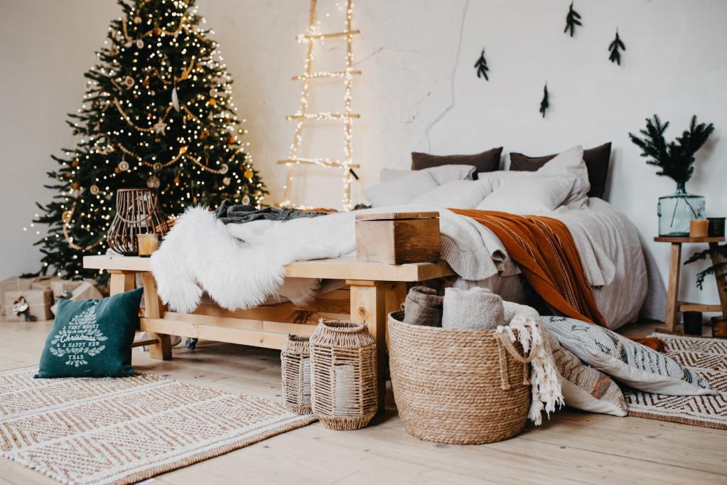 Comfortable bedroom in bohemian interior style, and a Christmas tree.