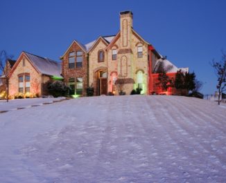 Snow Covered Yard and Stone House.